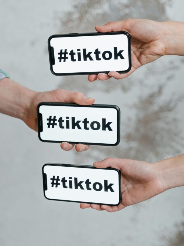 Hands holding smartphones displaying TikTok hashtag, emphasizing social media connection.