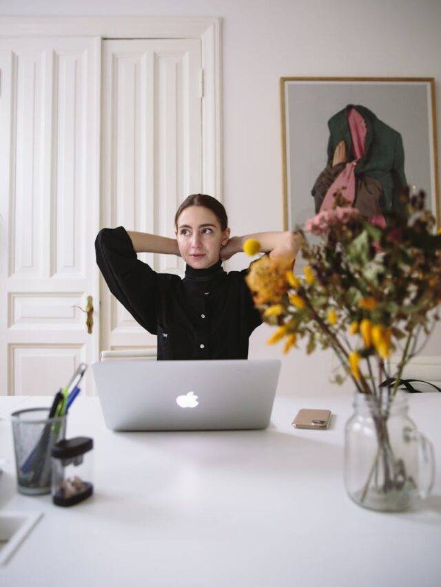 Relaxed woman in a modern office environment working remotely with a laptop and decor.